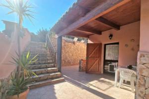 een patio met een trap, een tafel en een stoel bij Villa Susy Solanas -IUN R5389 in Solanas