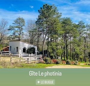 ein Bild eines Cottage mit einem Zaun und Bäumen in der Unterkunft Le Photinia in Le Bugue