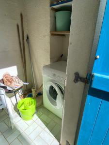 uma lavandaria com uma máquina de lavar roupa e uma mesa em Maisonnette dans résidence vacances, à 200m de la plage draps et linge de maison non fournis em Bretignolles-sur-Mer