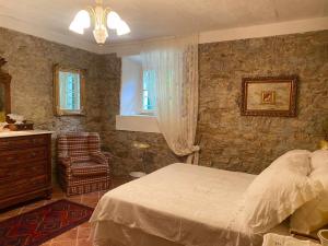 a bedroom with a bed and a stone wall at Villa Chicca in Neviano degli Arduini +77 photos
