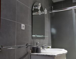 um banheiro com uma pia e um espelho em Apartamento Brisa Mar em Albufeira