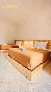 2 camas num quarto com uma cama de madeira em TANAWU AIRPORT HOTEL LOMBOK em Praya