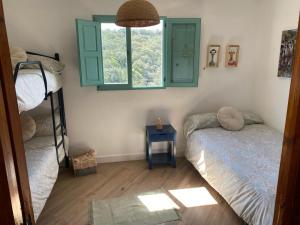 een slaapkamer met 2 stapelbedden en een raam bij Alojamiento La Casa del Pintor in Almonaster la Real
