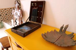 uma mesa amarela com uma caixa de madeira em cima em Alojamiento La Casa del Pintor em Almonaster la Real