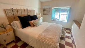 a bedroom with a bed with pillows and a window at Alojamiento La Casa del Pintor in Almonaster la Real +65 photos
