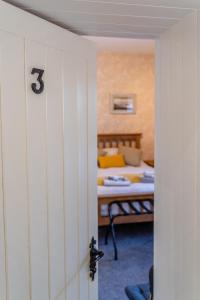 um quarto com uma cama e uma porta com um número treze em The Mulberrys B&B em Downpatrick