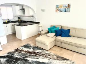 sala de estar con sofá y cocina en Luces Del Mar Beautiful bungalow with seaview near to Moraira en Benitachell