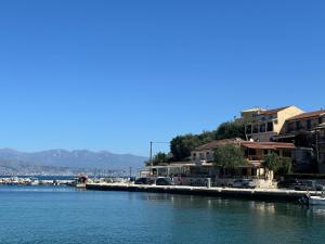a body of water with cars parked next to buildings at Virginia's Penthouse in Kassiopi +14 photos