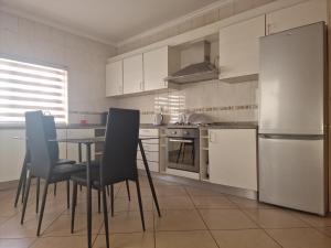 een keuken met een tafel en stoelen en een koelkast bij Kaps Home Miramar D in Praia