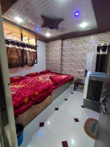 um quarto com uma cama vermelha e uma parede de pedra em Tamrakar Hotel and Restaurant em Ujaim