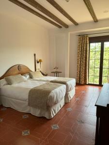 a bedroom with a large bed and a large window at Hotel Rural Cazorla Posada del Cordobés in Cazorla