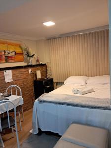 1 dormitorio con 1 cama, 1 mesa y 1 silla en Aconchego Vila Rica - Mariana, en Mariana