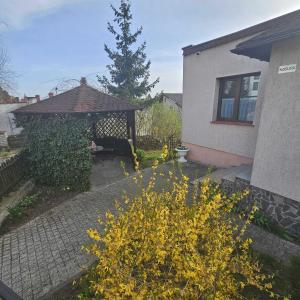 een tuin met een prieel en een boom bij Apartament Morskie Oko in Brodnica