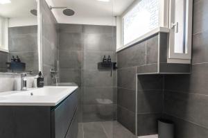a bathroom with a sink and a toilet at Contrada della Fontana Luxury Apartment in Levico Terme