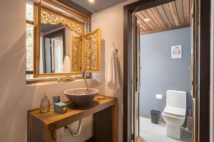 a bathroom with a sink and a mirror and a toilet at Casa Thai Linda na Praia in Barra de Ibiraquera +21 photos