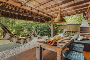patio con tavolo e cesto di frutta di Casa Thai Linda na Praia a Imbituba