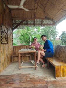 un homme et une femme assis à une table dans l'établissement Odambang Village Homestay, à Battambang