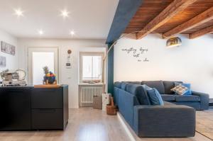 a living room with a blue couch and a kitchen at Contrada della Fontana Luxury Apartment in Levico Terme +34 photos