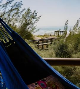 uma rede de descanso com vista para a praia em Villa Sayuri em Barra de Ibiraquera