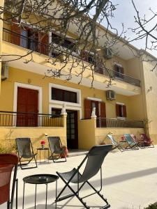 a group of chairs and a table in front of a building at Nicoll Apartments in Acharavi