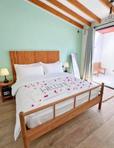 a bedroom with a large bed with flowers on it at Villa Laguna Maldives in Fulhadhoo +6 photos