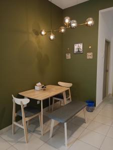 uma sala de jantar com uma mesa de madeira e 2 cadeiras em Homesbyfs Youth City KLIA em Nilai