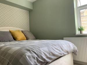 um quarto com uma cama com uma almofada amarela em Entire Bungalow with 2 car Parking.Stunning views em Bath