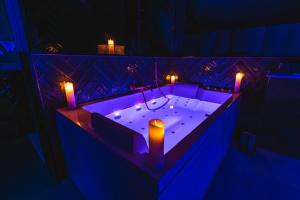 a bath tub with two candles in it with lights at Casa Love - Love Room in Quincy-Voisins