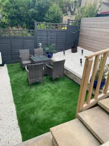 a patio with chairs and a table with green grass at Entire Bungalow with 2 car Parking.Stunning views in Bath
