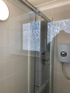 a shower with a glass door in a bathroom at Entire Bungalow with 2 car Parking.Stunning views in Bath