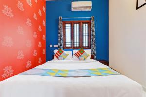 a bedroom with a bed with blue and red walls at SAI BALAVANY RESIDENCY Pondicherry in Puducherry