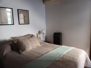 a bedroom with a bed with a green and white comforter at La Casa de al Lado con Garage !!! in La Plata