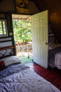 1 dormitorio con 1 cama y puerta con ventana en Cabaña entre las montañas santa cruz Penonomé en Penonomé