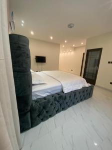 een slaapkamer met een groot bed en een stapel dekens bij Luxe Vista Villa in Kumasi