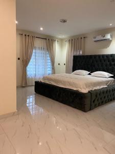 a large bed in a bedroom with a marble floor at Luxe Vista Villa in Kumasi