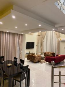 a living room with a table and a couch at Luxe Vista Villa in Kumasi