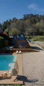 a pool with a chair next to a house at Casas da Madrinha in Arcos de Valdevez
