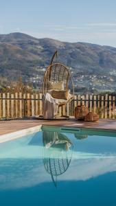 a wicker chair sitting next to a swimming pool at Casas da Madrinha in Arcos de Valdevez