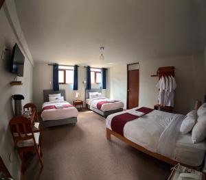 Cette chambre comprend 3 lits et une chaise. dans l'établissement TerraMistica Colca, à Coporaque