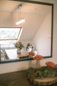 ein Spiegel in einem Raum mit einem Tisch und einem Fenster in der Unterkunft FERIENWOHNUNG "Deichort" Meppen in Meppen