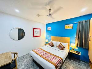 1 dormitorio con cama y pared azul en Hotel Golden Saffron - Punjabi Bagh Delhi en Nueva Delhi