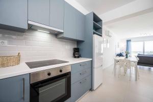 a kitchen with blue cabinets and a table in it at Villa Xenos Rose in Tigaki