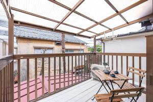 une pergola sur un balcon avec une table et des chaises dans l'établissement Himawari, à Tokyo