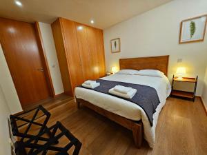 ein Schlafzimmer mit einem Bett mit zwei Handtüchern darauf in der Unterkunft BUTEKO HOUSE AL in Miranda do Douro