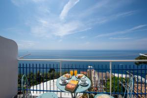 a table on a balcony with a view of the ocean at Sogno Blu in Furore