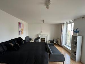 a living room with a black couch and a fireplace at Luxury Stay near London Eye zone 1 in London