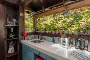 a kitchen counter with a sink and a window at Studio Thai na praia in Imbituba