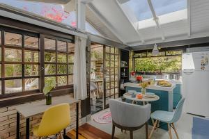 a kitchen and dining room with a table and chairs at Studio Thai na praia in Barra de Ibiraquera