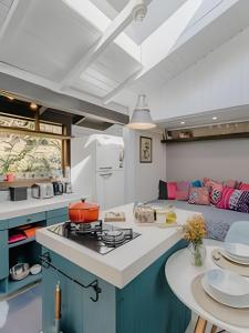 a kitchen with blue cabinets and a stove top oven at Studio Thai na praia in Barra de Ibiraquera +16 photos