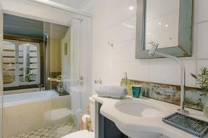 a white bathroom with a sink and a shower at Studio Thai na praia in Imbituba